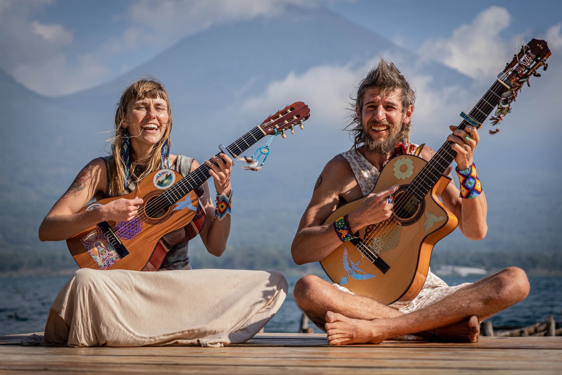 Jahendo and Sunny Day playing guitar on the dock at Lake Atitlán
