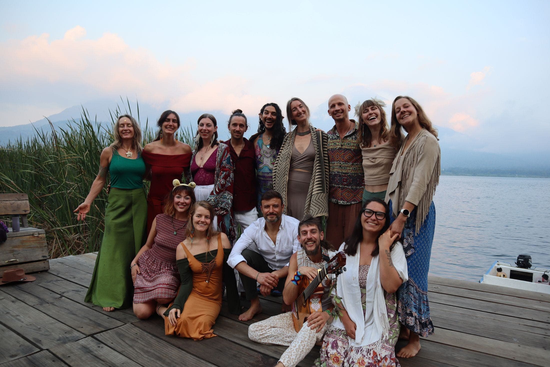 Community gathered on the dock at Mystical Yoga Farm, volcanoes across the lake