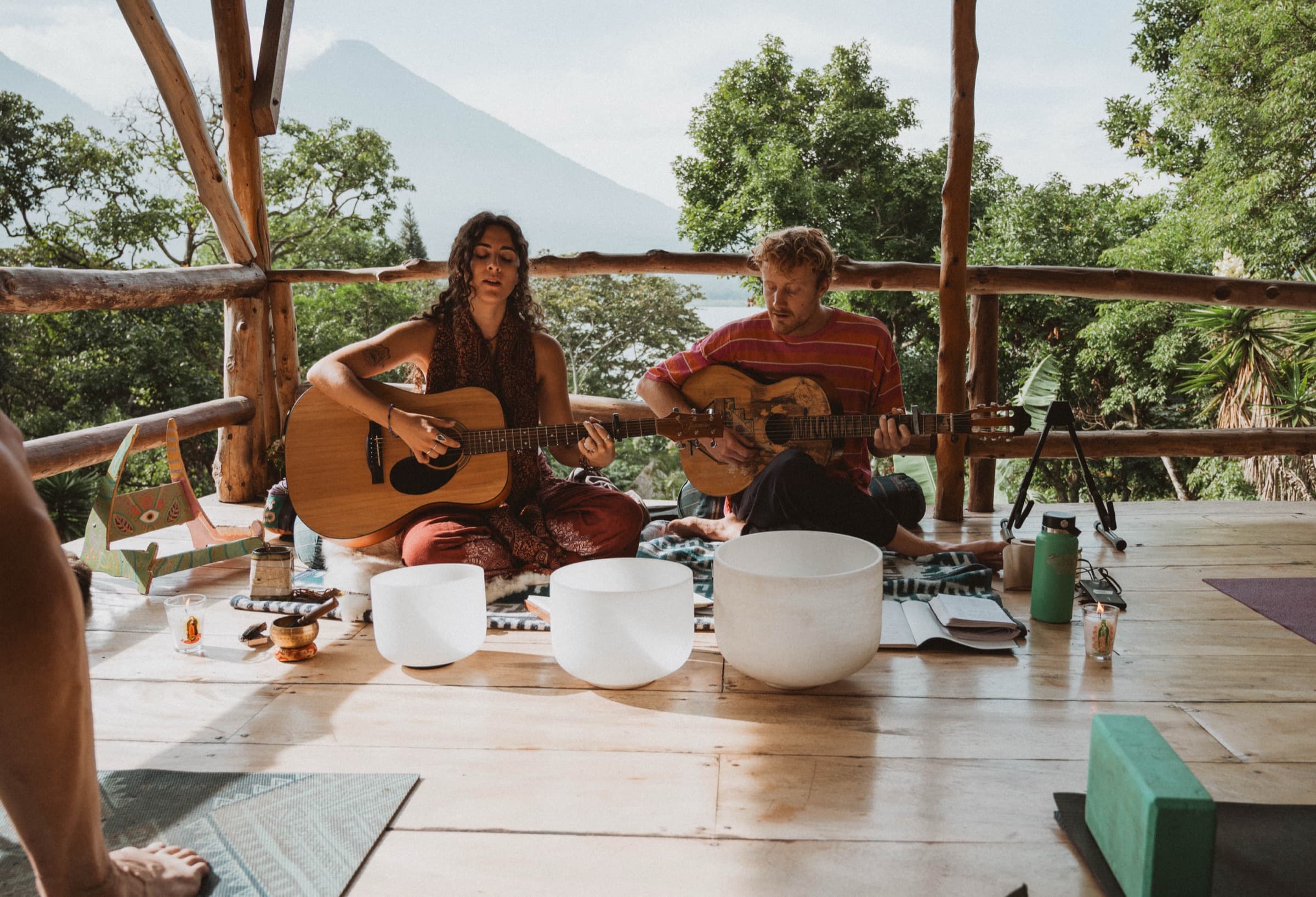 Guitar and singing bowls on the deck, Lake Atitlán and a volcano beyond