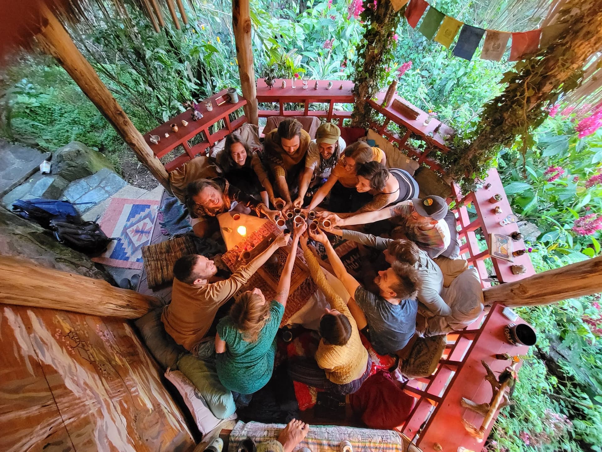Guests seated in a circle in the tea house, raising cups together at communiTea