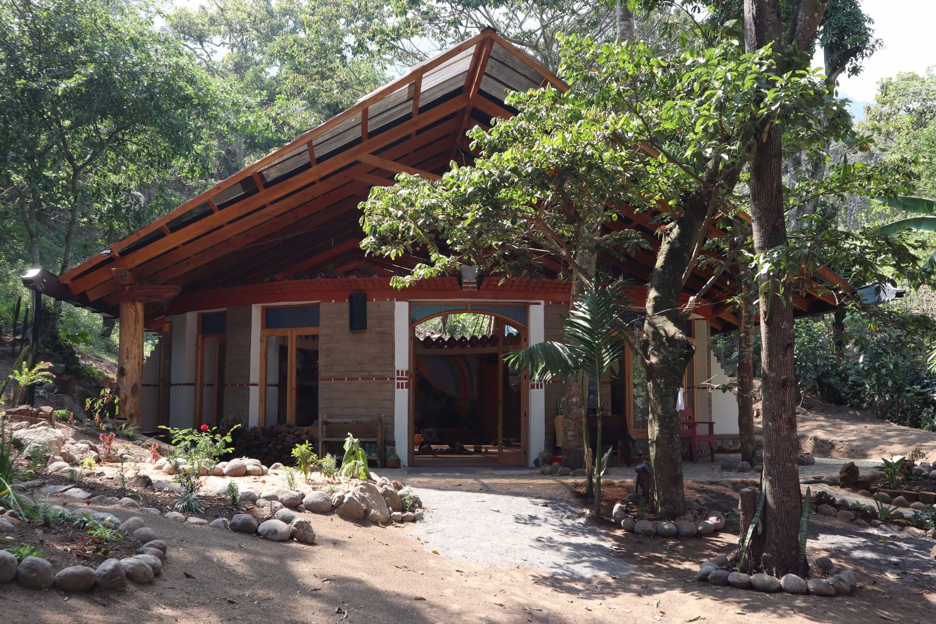 Temple da Jiboia from outside: wooden roof, earth walls, forest around it